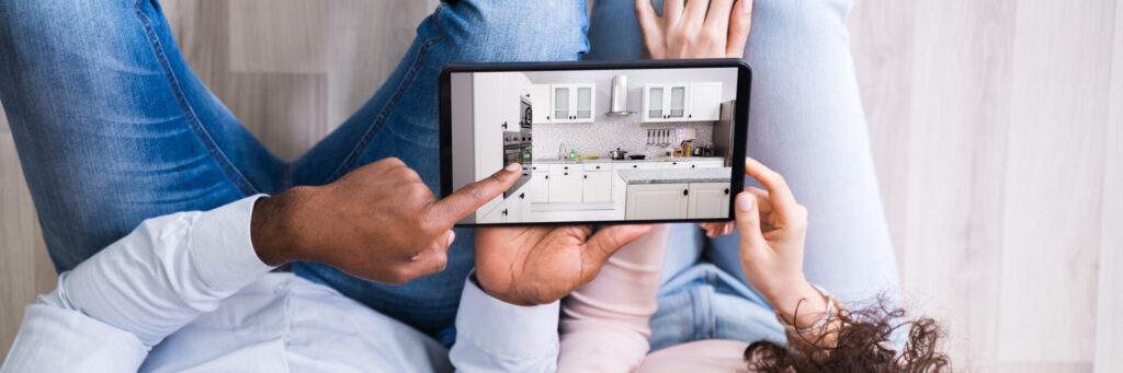 Couple holding a tablet and thinking about kitchen remodeling in white style